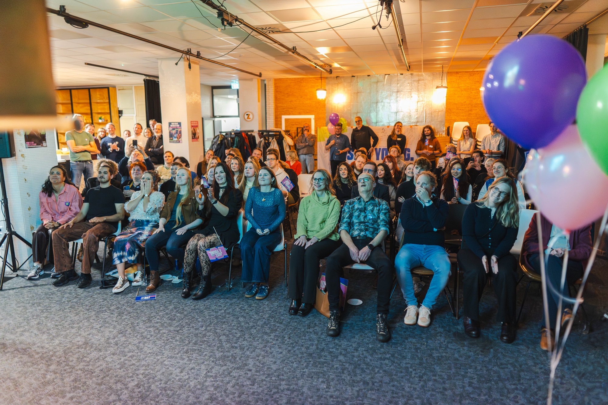 Een groep mensen luistert naar de uitslag van de jury van European Youth Capital